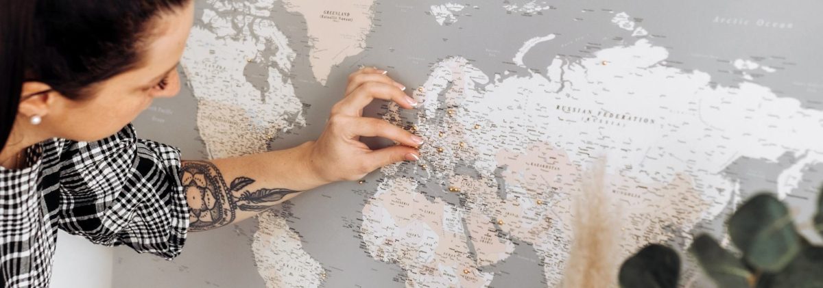 minimal-modern-world-map-with-pins-grey-cream-1p-aspect-ratio-1140-400